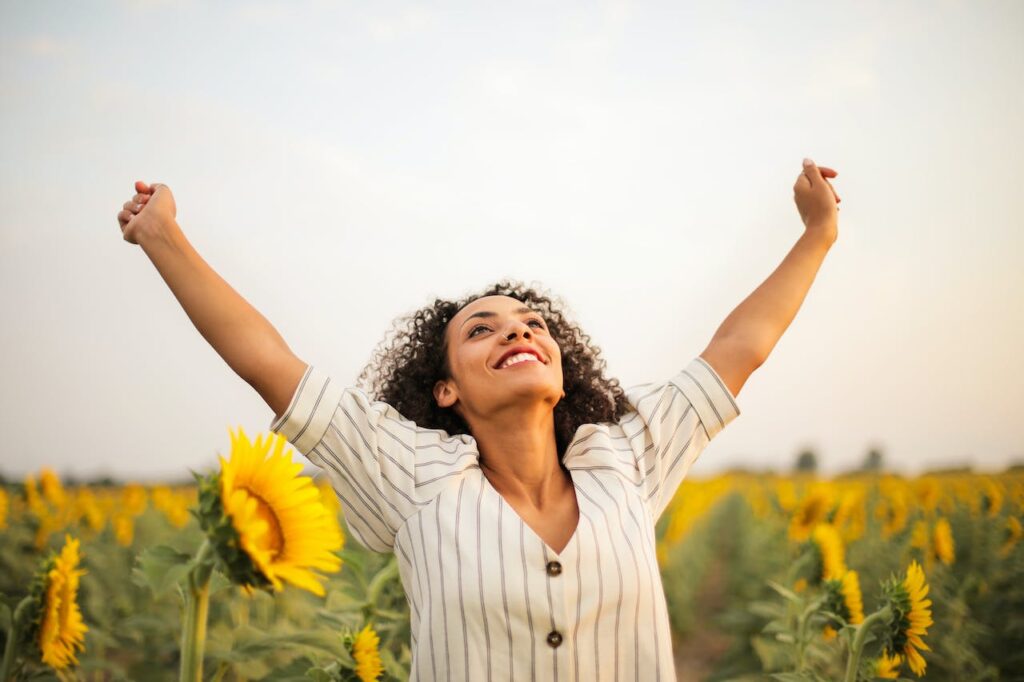 Power of Alignment happy woman in a sunflower field